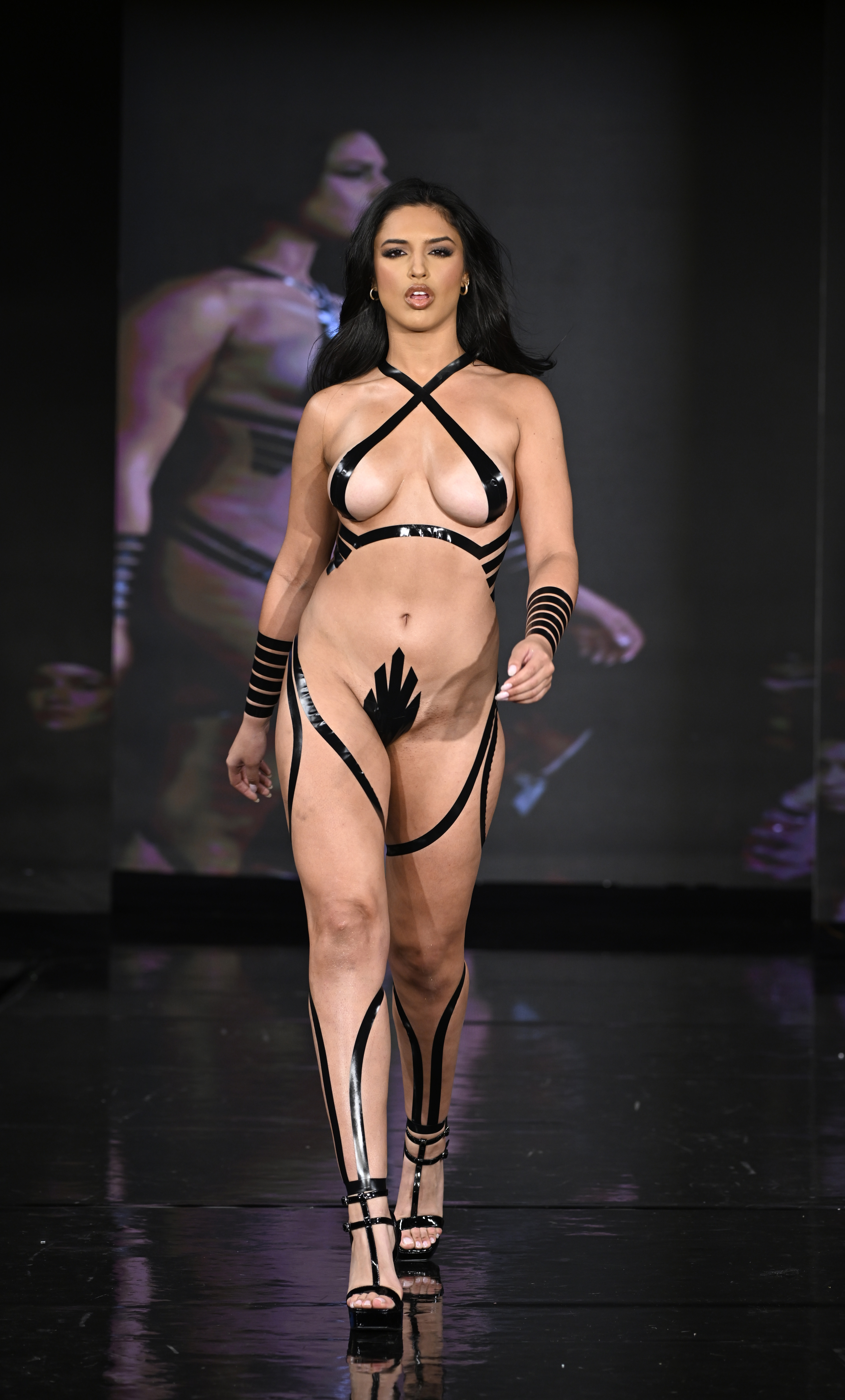 A model walked the runway wearing a bikini, accessories, and shoes made out of tape