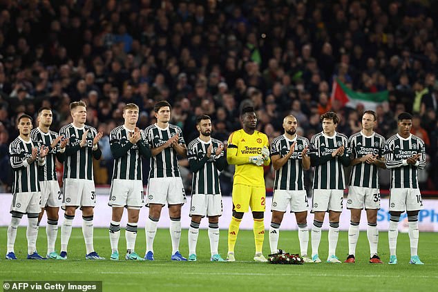 Manchester United players observe a minute's applause for legendary United and England midfielder Sir Bobby Charlton whose death was announced this evening