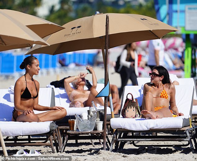 In good company: The star was joined by a female friend as she topped up her tan on Thursday