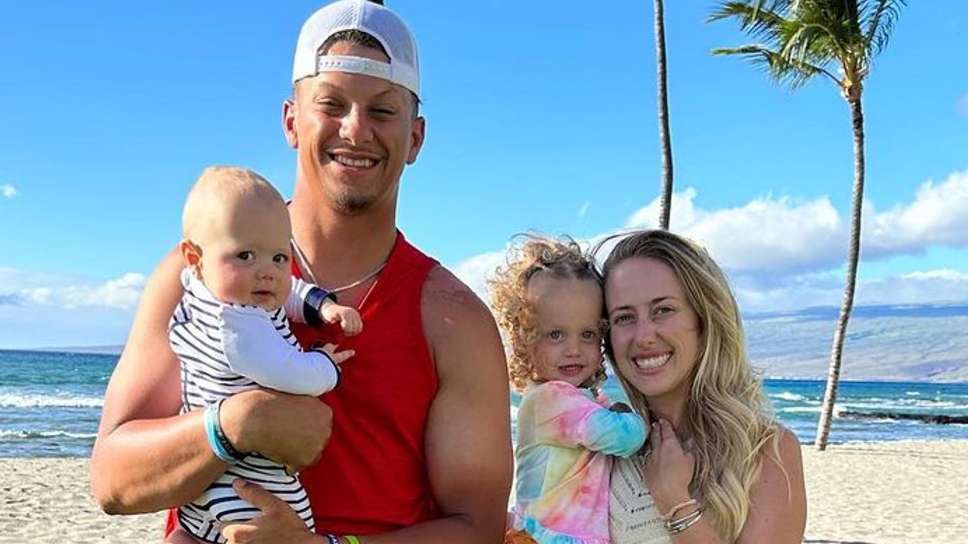 Patrick and Brittany Mahomes stand with their children on the beach